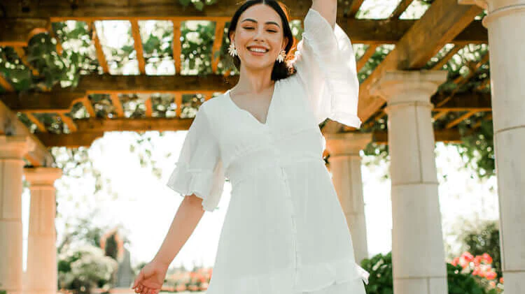model wearing a white flutter sleeve midi dress