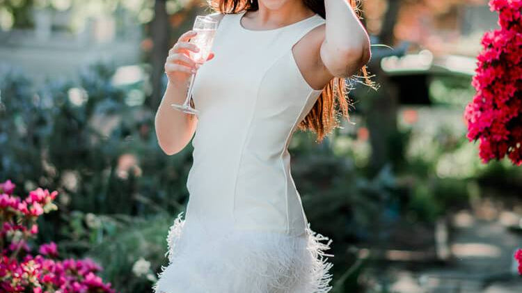 model wearing a white feather mini dress