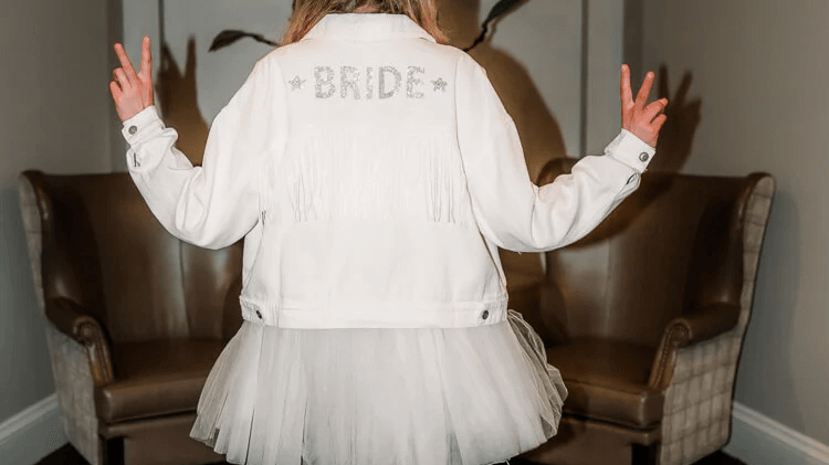 woman wearing a white sequin “Bride” denim jacket