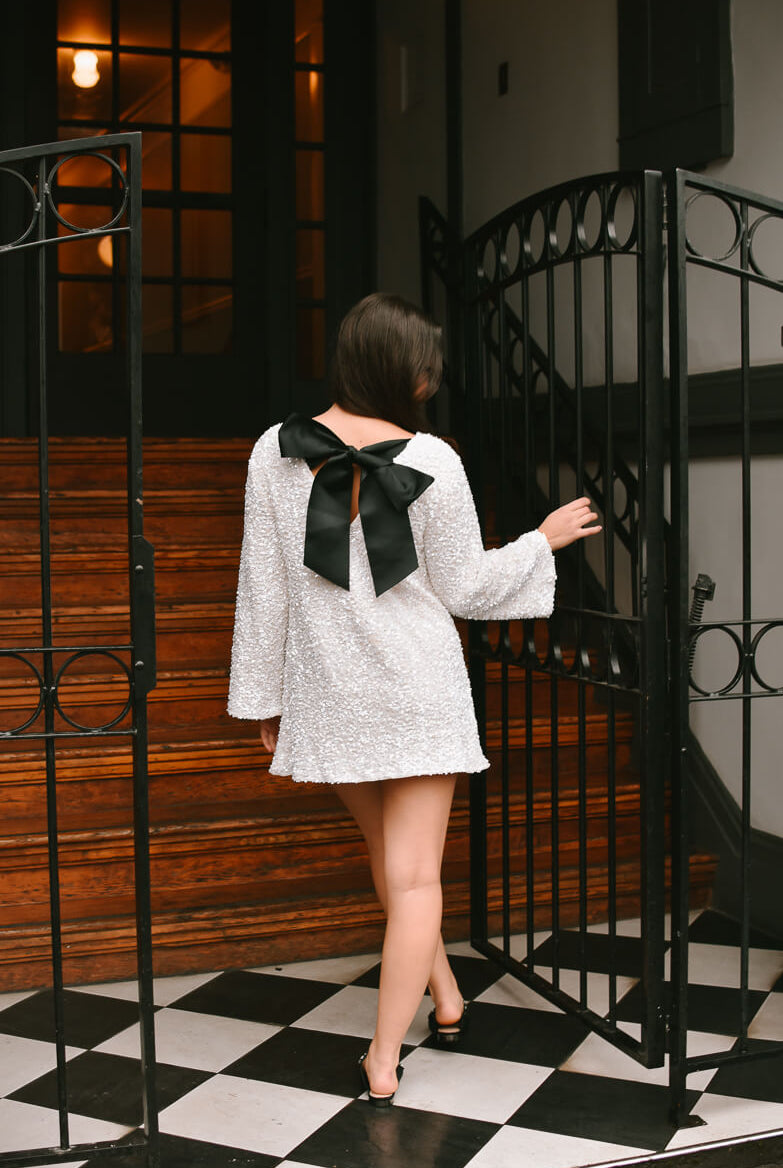 viral white sequin mini dress with black bow tie back, white sequin mini dress with black bow