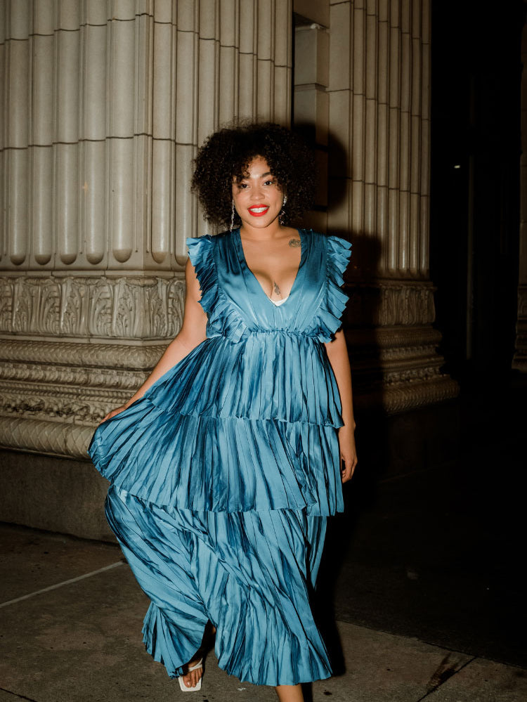  a woman wearing a blue tiered maxi dress at night.