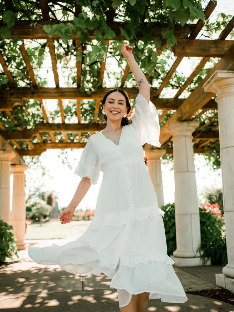 model wearing a white flutter sleeve midi dress