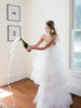 model popping champagne in a dramatic tulle wedding dress