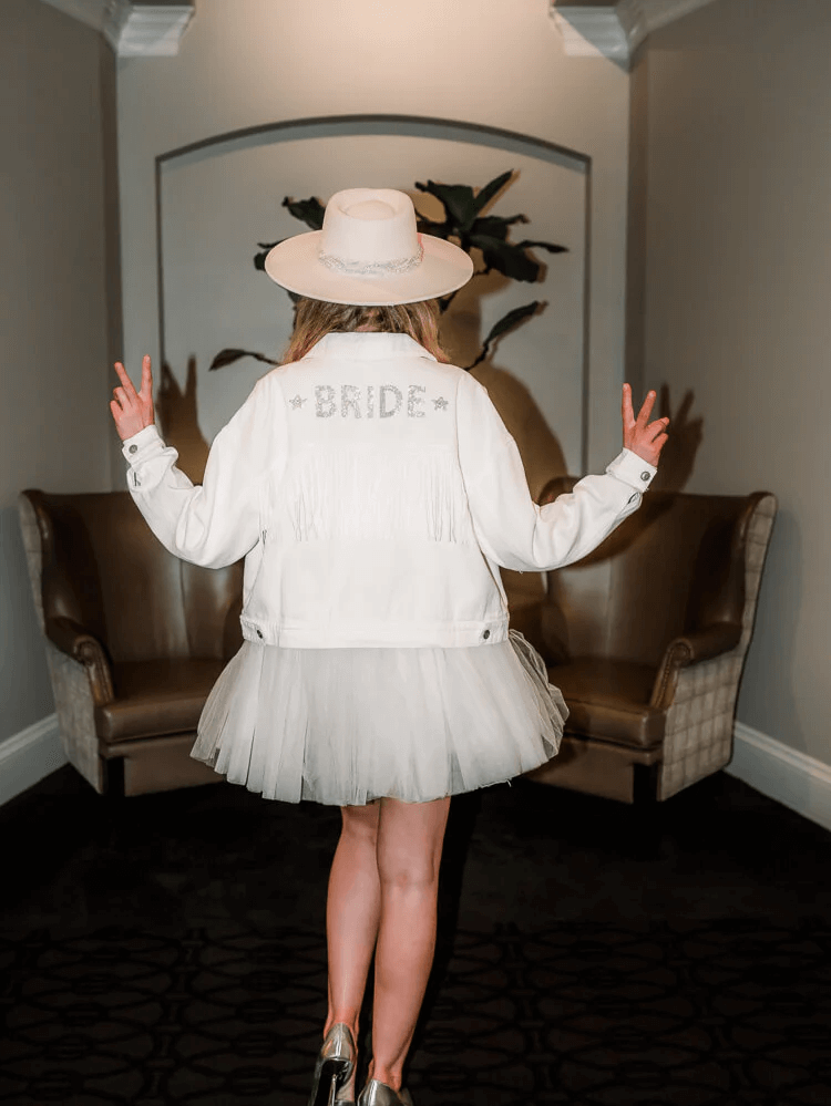 woman wearing a white sequin “Bride” denim jacket