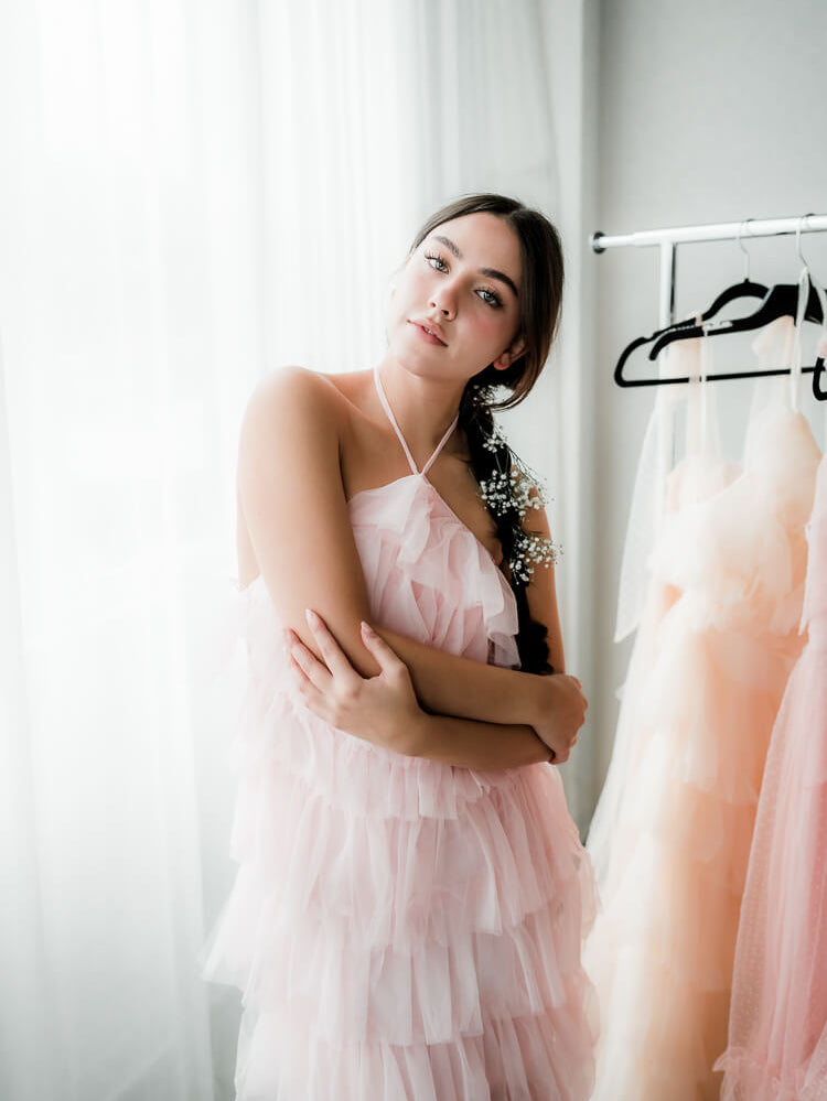 model in a pink tulle dress with arms crossed.