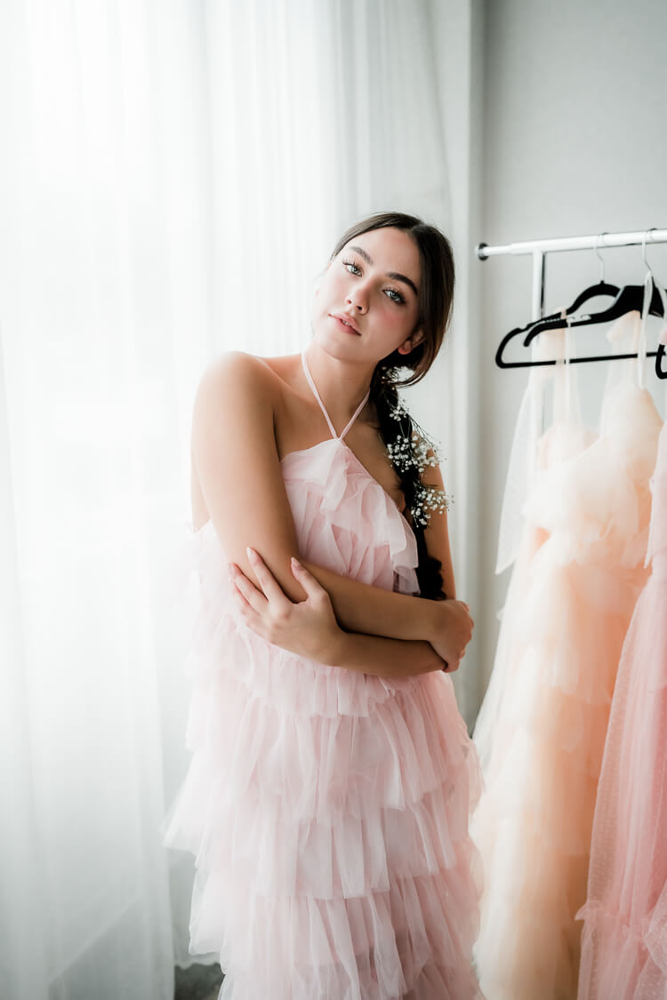 model in a pink tulle dress with arms crossed.