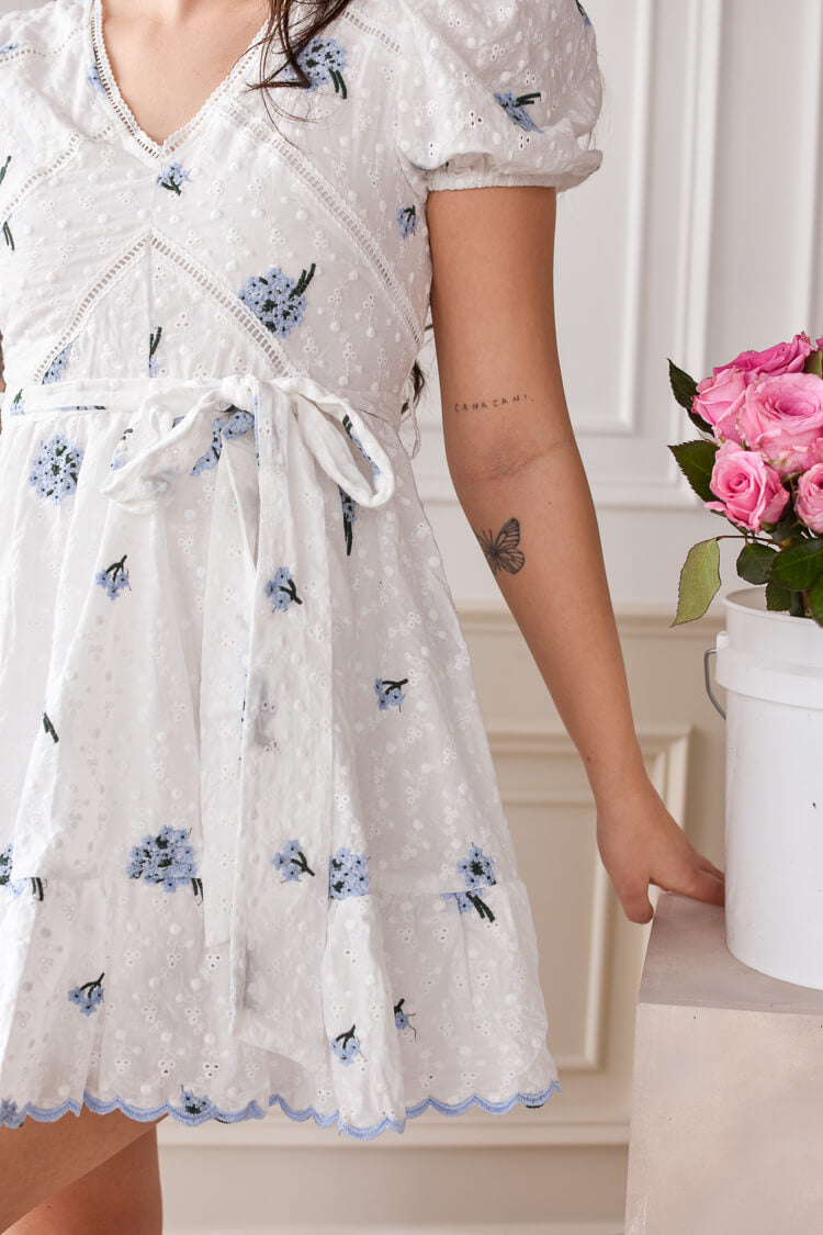 white eyelet mini dress with blue embroidered flowers