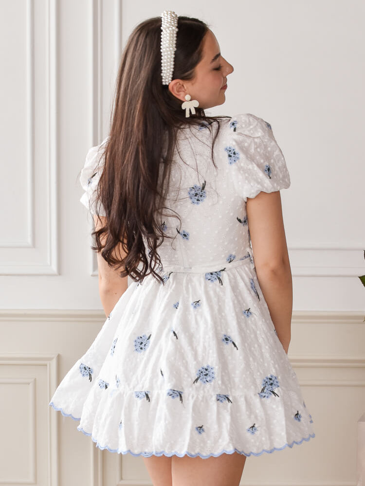 white eyelet mini dress with blue embroidered flowers