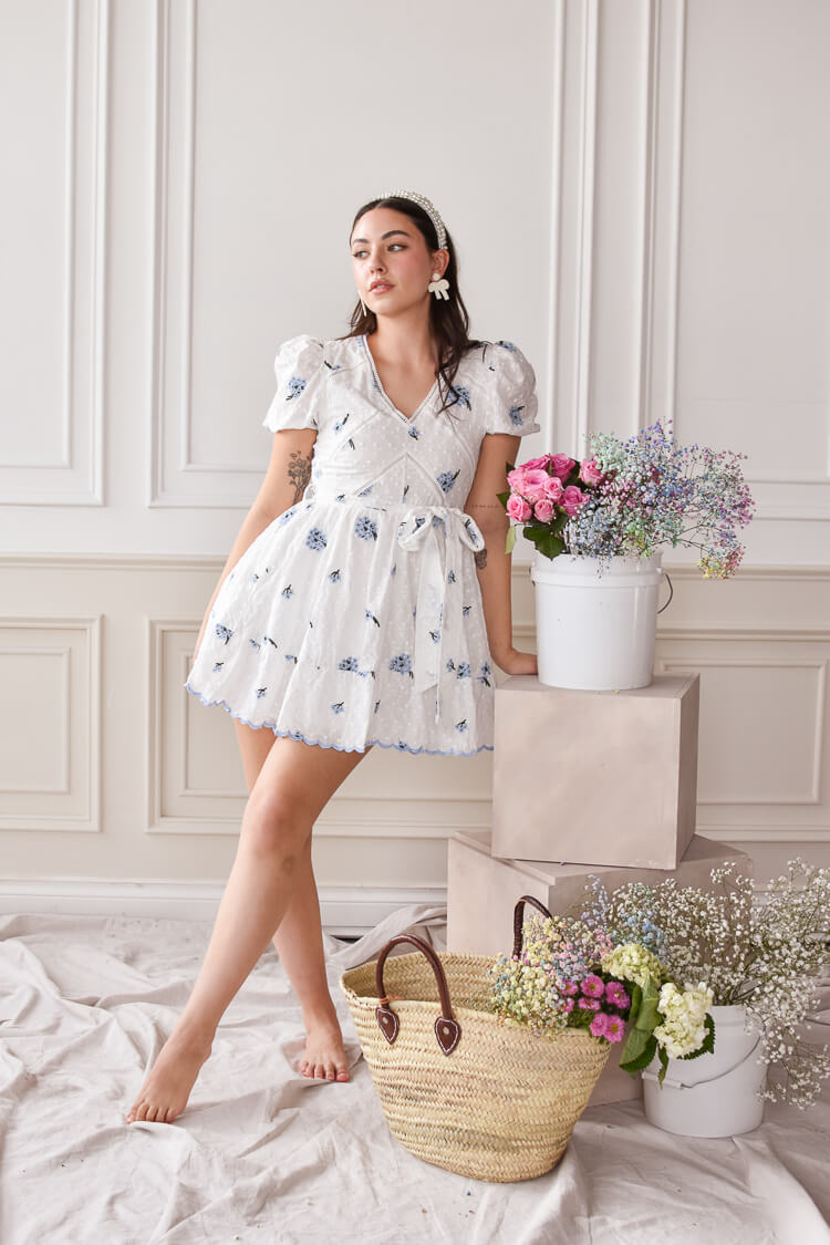 white eyelet mini dress with blue embroidered flowers