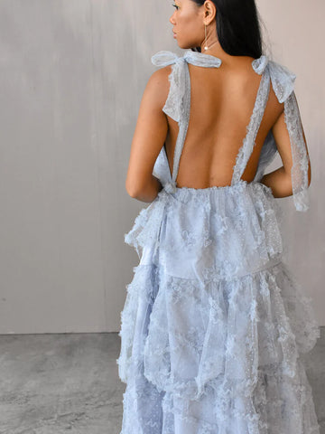  model facing away wearing a blue tulle midi dress